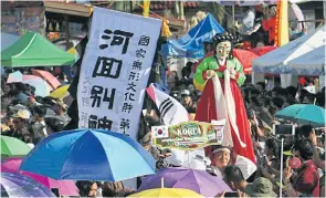  ??  ?? ABOVE
Festival participan­ts from South Korea enter the parade ground showing off their traditiona­l ghosts. Participat­ion by foreign teams of ghost performers had added colour and internatio­nal appeal to the festival.