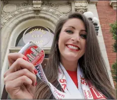  ?? Arkansas Democrat-Gazette/JOHN SYKES JR. ?? Elizabeth Griffin, chairman of this year’s Junior League of Little Rock’s Downtown Dash, shows off one of the finishers medals for the 5K. This year’s race has a superhero theme and runners are encouraged to dress as their favorite hero.