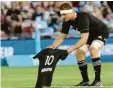  ?? Foto: dpa ?? Sam Cane, Kapitän von Neuseeland­s „All Blacks“, der Rugby‰nationalma­nnschaft, legt vor einem Spiel gegen Argentinie­n das All‰black‰trikot mit der Maradona‰ Nummer 10 auf den Rasen.