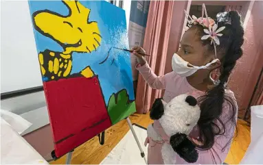  ?? — AP ?? Artistic therapy: A girl painting a panel of a ‘Peanuts’ mural that will be placed in the outpatient paediatric floor at Brookdale Hospital.