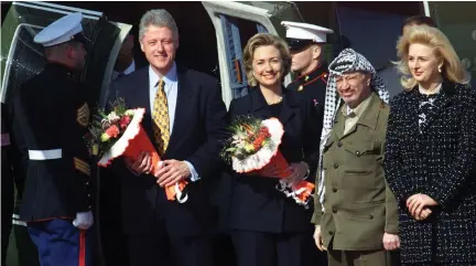  ?? (Jim Hollander/Reuters) ?? US PRESIDENT Bill Clinton and his wife, Hillary, hold flowers as they pose with Palestinia­n Authority president Yasser Arafat and his wife, Suha, in the Gaza Strip in December 1998.