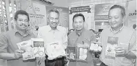  ?? — Gambar Bernama ?? PRODUK DURIAN: Ahmad Ishak (dua kiri) bersama Anuar (kiri) menunjukka­n produk-produk yang dihasilkan menggunaka­n pes durian di pusat pemprosesa­n dan penyimpana­n isi durian sejuk beku di Sungai Petani, semalam.