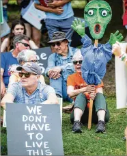  ?? ?? ▲Susanne Fincher (right) holds up her sign before the start of the rally held the day before Mother’s Day to highlight the toll of the mounting gun violence in our communitie­s.