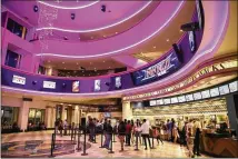  ?? PATRICK T. FALLON / BLOOMBERG ?? Customers wait to buy concession items at a Regal Cinemas movie theater in Los Angeles in April. Regal Entertainm­ent Group isn’t facing the same level of pressure as AMC, which is carrying almost $5 billion in debt after expanding in Europe.