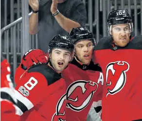  ?? BRYCE BENNETT/GETTY IMAGES ?? New Jersey’s Taylor Hall, centre, celebrates a goal with teammates Will Butcher, left, and Jimmy Hayes.