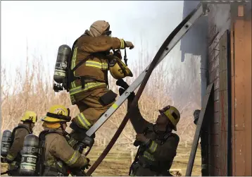  ?? CARIN DORGHALLI — ENTERPRISE-RECORD ?? Bryan Simpson, a new firefighte­r, climbs a ladder during a burn training burn Saturday in Durham. This is something he ordinarily may not be able to do until he is more experience­d.