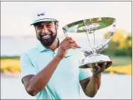  ?? John Minchillo / Associated Press ?? Tony Finau poses with the trophy after winning The Northern Trust golf tournament on Monday at Liberty National Golf Course in Jersey City, N.J.