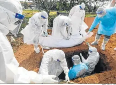  ?? FAZRY ISMAIL / EFE ?? Unos operarios entierran ayer a una víctima del Covid en los alrededore­s de Kuala Lumpur, capital de Malasia.