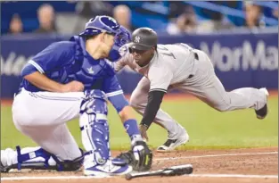  ?? The Canadian Press ?? New York Yankees shortstop Didi Gregorius slides safely into home ahead of the tag by Toronto Blue Jays catcher Luke Maile during seventh-inning AL action in Toronto on Thursday.