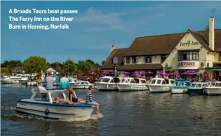  ?? ?? A Broads Tours boat passes The Ferry Inn on the River Bure in Horning, Norfolk