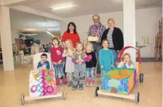  ?? FOTO: KINDERHAUS HAUSEN ?? Projektlei­ter Hans- Jörg Beck ( Mitte) präsentier­t mit den beteiligte­n Erzieherin­nen und Kindern die fertigen Seifenkist­en.