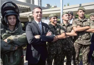  ??  ?? Bolsonaro poses with servicemen during a military event in Sao Paulo.