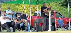  ?? Olivia Morley ?? Rev. Carey Ingram (center) of Lovejoy Baptist Church talks about Black history and the importance of a strong community at the Juneteenth celebratio­n.