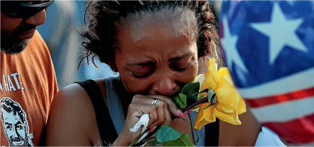  ?? REUTERS ?? Keaka Wallace, former patrol partner of shooting victim Brent Thompson, weeps as she leaves a makeshift memorial outside Dallas Police Headquarte­rs.