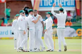  ??  ?? South Africa bowler Kagiso Rabada is celebrated after taking the wicket of Australia batsman and captain Steve Smith during day one of the second Sunfoil Test against Australia at Port Elizabeth - AFP