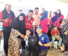  ??  ?? Ahmad Marzuki presenting the school bags and stationery to the pupils.