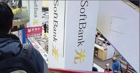  ?? — AP ?? Major investor: A shopper standing on an escalator passes by SoftBank logo at an electronic shop in Tokyo. The Japanese company, which just closed its Vision Fund, disclosed it owned an unspecifie­d amount of Nvidia stock when it announced US$93bil of...