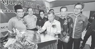  ??  ?? KELAI: Naroden nyain plak kelai udah bejadika Begunan Raya Khas, seraya dikemataka (kiba) Juanda enggau (belakang YB Naroden, kanan) Johnny enggau ke bukai.