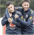  ??  ?? Brazil’s Neymar (right) hugs Philippe Coutinho (left) during a soccer team training session in London recently.