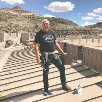  ??  ?? Vance Neudorf, executive director of the Badlands Passion Play, helps with constructi­on of a 5,000-square-foot addition to the Badlands Arts Centre. The play though, has been cancelled.