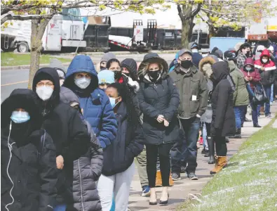  ?? CHRIS HELGREN / REUTERS ?? Residents 18 years of age and older who live in COVID-19 “hot spots” line up in Toronto on Wednesday
at a special a vaccinatio­n clinic run by Humber River Hospital's mobile team.