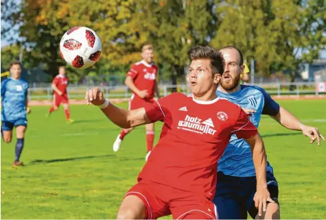  ?? Foto: Rudi Fischer ?? Den Ball und eine hoffentlic­h bessere Zukunft voll im Blick hat hier Merings Harald Kerber (rotes Trikot). Das 2:0 gegen den starken Aufsteiger aus Garmisch-Partenkirc­hen könnte für die Meringer die Wende zum Besseren sein.