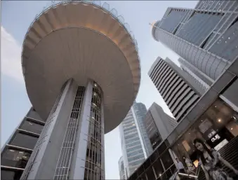  ?? -AP ?? People pass the skyline of the central business district of Singapore.