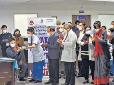  ?? AMAL KS/HT PHOTO ?? Sanitiatio­n worker Manish Kumar was the first person in the Capital to be administer­ed a Covid-19 jab as Union health minister Dr Harsh Vardhan and Dr Randeep Guleria look on at AIIMS on Saturday.