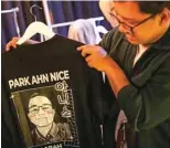  ?? ?? A man holds a t-shirt bearing an image depicting the face of Presidenti­al candidate Anies Baswedan, with his name changed from “Pak” (Mr in Indonesian) Anies, to a more Korean-sounding name “Park Ahn Nice”.