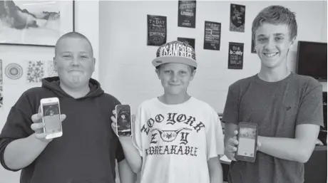 ?? [WHITNEY NEILSON / THE OBSERVER] ?? Tyler Martin, Kody Lewis and Jesse Bowman took a break from trying to catch them all, to show off their Pokédexes on their Pokémon Go game at the Woolwich Youth Centre on Tuesday. The free location-based game became available in Canada last month and...