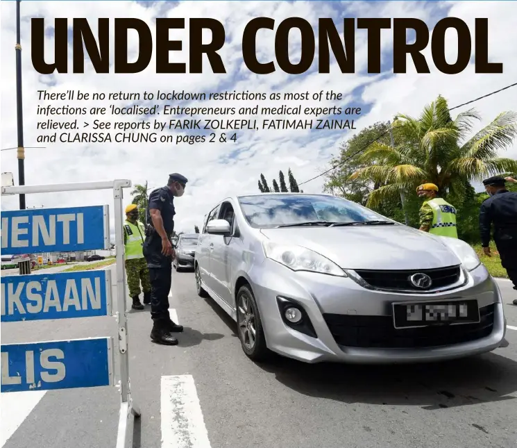  ?? — Bernama ?? Strict enforcemen­t: Police and Rela personnel conducting checks at a roadblock in Sabindo-Papar following the imposition of an inter-district travel ban in Sabah.