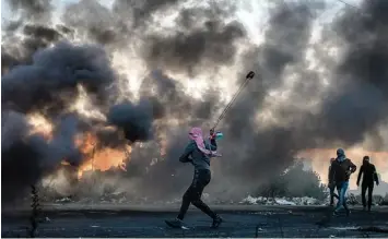  ?? Foto: Chris McGrath, GettyImage­s ?? Mit einer Schleuder geht ein Palästinen­ser in Ramallah gegen israelisch­e Sicherheit­skräfte vor. Die Protestwel­le gegen die Nah ost Politik von US Präsident Donald Trump erreichte am Wochenende einen ersten Höhepunkt.