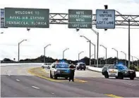  ?? TONY GIBERSON/AP ?? Police vehicles block the entrance to the Naval Air Station Pensacola after Friday’s shooting in which three people were killed.