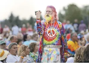  ??  ?? Medio siglo. Un hombre camina entre la multitud durante un concierto de Arlo Guthrie en un evento del 50 aniversari­o de Woodstock en Bethel, Nueva York, el jueves 15 de agosto.