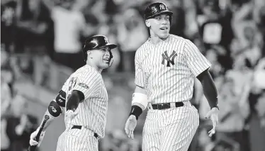  ?? Elsa / Getty Images ?? Aaron Hicks, left, welcomes Aaron Judge after Judge scored as part of the Yankees’ four-run sixth inning.