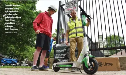  ?? SUN-TIMES FILES ?? Daniel Chovanec prepares to try out an electric scooter as he gets instructio­ns from Lime operations manager Matt Donelan.