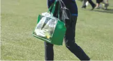  ?? — Reuters ?? A woman walks with a full shopping bag during the Drive, Chip and Putt National Finals at the Augusta National Golf Course in Augusta, Georgia, US.