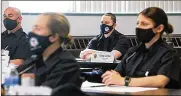  ?? JEFF LANGE / AKRON BEACON JOURNAL ?? Akron police cadet Jordan Costy (center) listens Monday during a class on crime scenes at the Akron police training facility.