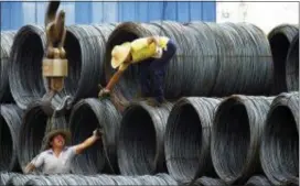  ??  ?? Laborers work in the steel market in Yichang in central China’s Hubei province. China has expressed “grave concern” about a U.S. trade policy report that pledges to pressure Beijing but had no immediate response to President Donald Trump’s plan to hike tariffs on steel and aluminum. The Commerce Ministry said Friday that Beijing has satisfied its trade obligation­s and appealed to Washington to settle disputes through negotiatio­n.