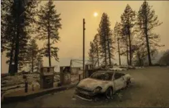  ??  ?? As the Camp Fire burns nearby, a scorched car rests by gas pumps near Pulga, Calif., on Nov. 11.