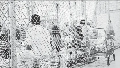  ?? U.S. CUSTOMS AND BORDER PROTECTION SERVICES TNS ?? In this photo provided by U.S. Customs and Border Protection, people who've been taken into custody related to cases of illegal entry into the United States, sit in one of the cages at a facility in McAllen, Texas in June