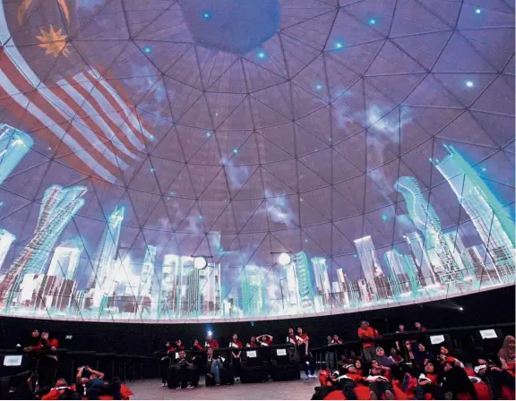  ??  ?? Visual feast: Students watching a video being projected onto the roof at the Expo Negaraku at Dataran Merdeka. — AZHAR MAHFOF/ The Star