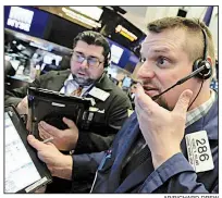  ?? AP/RICHARD DREW ?? Trader Michael Milano (front) watches stocks plummet Thursday morning on the floor of the New York Stock Exchange. By day’s end, all the 2018 gains for the Dow Jones industrial average had been wiped out.