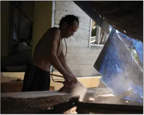  ?? (AP/Dita Alangkara) ?? Jembong, a boat maker, operates an electric planer at his workshop on Karampuang Island, in West Sulawesi, Indonesia, in December.