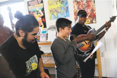  ?? Photos by Lea Suzuki / The Chronicle ?? Poet mentor Jarvis Subia (left) and teaching artist Terrence Brewer listen as a Martin Luther King Jr. sixth-grader reads a poem.