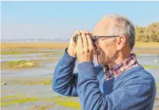  ?? FOTOS: ANDY HEINRICH ?? Jemand den See gesehen? Gerhard Kersting, Leiter des Naturschut­zzentrums in Eriskirch (rechts), hält am Schwedi Ausschau nach Pflanzen und Tieren, die das breite Ufer voll ausnutzen, das ihnen das Niedrigwas­ser gerade bietet.