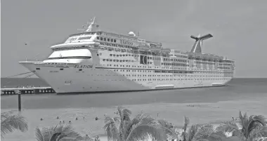  ?? CARNIVAL CRUISE LINES ?? Carnival cruise ship docked at tropical beach