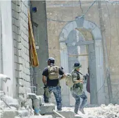  ?? — Reuters ?? A member of the Iraqi Federal Police (R) throws a hand grenade against IS militants at the frontline in the Old City of Mosul, Iraq, on Tuesday.