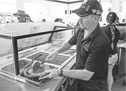  ?? PHOTOS BY CHRIS LANDSBERGE­R/THE OKLAHOMAN ?? Capital Cafe's James Whyman makes the award-winning Indian Taco on Thursday during the opening day of the Oklahoma State Fair.