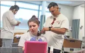  ?? / Contribute­d ?? Students in GNTC’S EMT program prep for the drill by role-playing victims. Madison Nelms (sitting) is having an artificial wound applied by classmate Mike Chavez. Fellow student Phoenix West helps in the background.